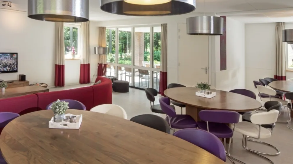 Woonkamer met tafels en zithoek met bank Hoeve
